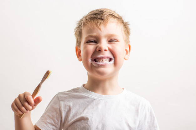 mignon garçon mignon posant avec brosse à dents en bambou sa bouche enfant brosse ses dents