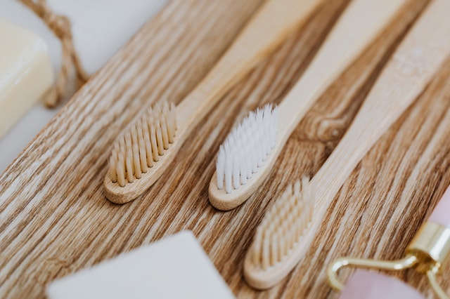Trois brosses à dents sur un support en bois